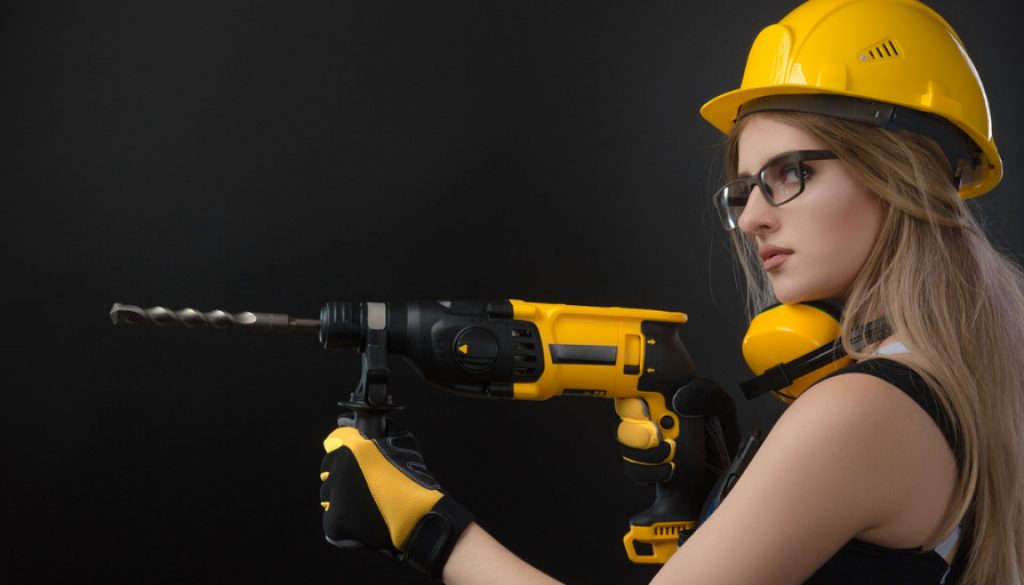 girl-in-construction-clothes-and-protective-equipment-posing-with-a-picture-id1084423610