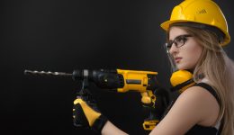girl-in-construction-clothes-and-protective-equipment-posing-with-a-picture-id1084423610