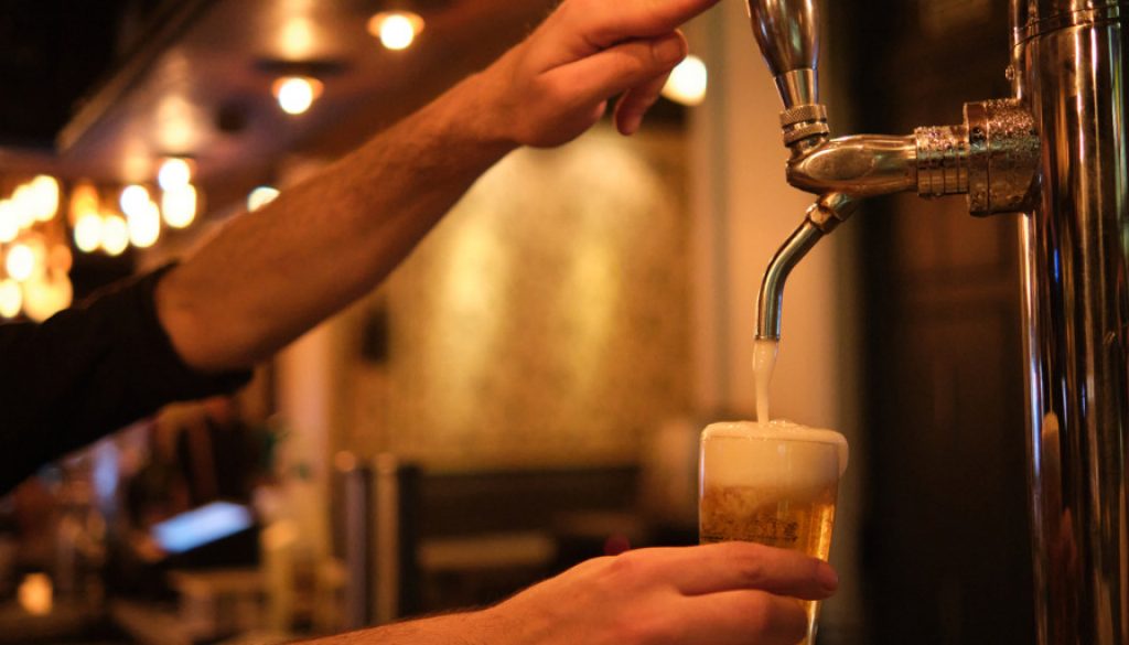 barman-pouring-beer-in-glass-from-beer-tap-picture-id1293276420