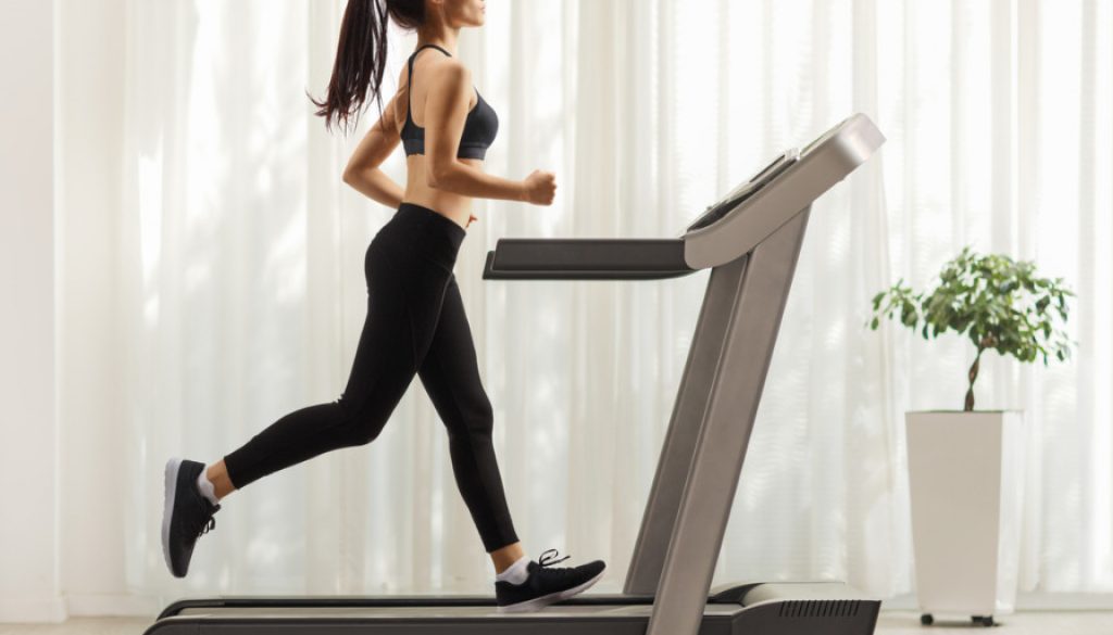 young-woman-running-on-a-treadmill-indoors-picture-id1202049171